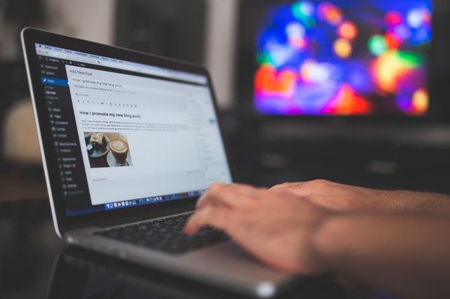 Zoomed in picture of a person's hands on a laptop while they write on their blog